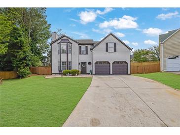 Charming two-story home featuring a manicured front yard and a two-car garage at 1701 English Ivey Nw Ln, Kennesaw, GA 30144