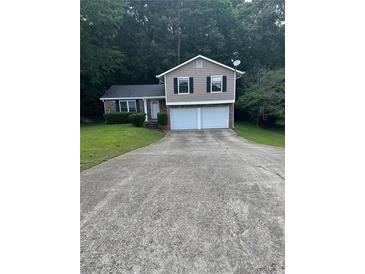 Charming two-story home featuring a two-car garage and a well-maintained front yard at 5388 Robertson Path, Lithonia, GA 30038