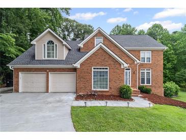 Charming brick two-story home with a two-car garage and well-manicured lawn at 1784 Brookstone Nw Ct, Acworth, GA 30101