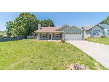 Charming single-story home with a well-manicured lawn and attached two-car garage on a sunny day at 647 New England Way, Lawrenceville, GA 30046