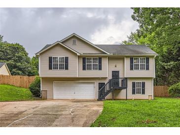 Charming two-story home featuring neutral siding, black shutters, and an attached two car garage at 275 Mountain Way, Covington, GA 30016