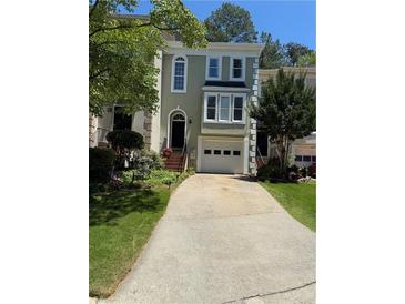 Charming townhome with a two-car garage, complemented by beautiful landscaping and a welcoming entrance at 3697 E Bay St, Duluth, GA 30096