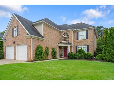Charming brick two-story home with well-manicured lawn, attached two-car garage, and beautiful architectural details at 3032 Montclair Se Cir, Smyrna, GA 30080