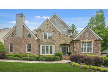 Beautiful brick and stone home featuring manicured landscaping and a charming front entrance at 702 Crescent Cir, Canton, GA 30115