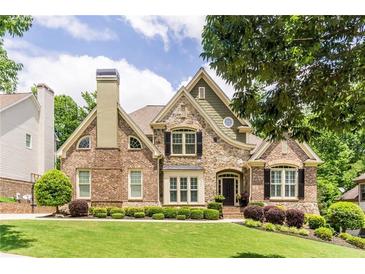 Beautiful brick and stone home with manicured landscaping and a charming architectural design at 702 Crescent Cir, Canton, GA 30115