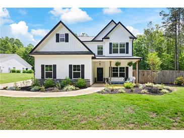 Charming two-story home featuring black shutters and a cozy front porch with stylish outdoor seating at 1417 Woodrow Kay Rd, Rockmart, GA 30153
