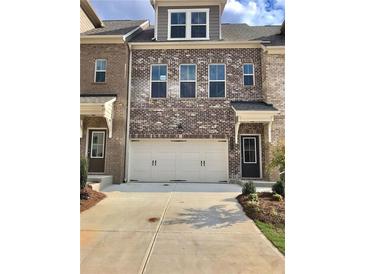 Charming brick townhome with a two-car garage and inviting curb appeal at 3677 Hidden Valley Cir, Lawrenceville, GA 30044