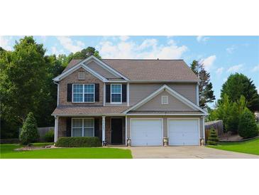 Charming two-story home featuring a brick and vinyl facade, well-manicured lawn, and a two-car garage at 4687 Riley Run Ct, Sugar Hill, GA 30518