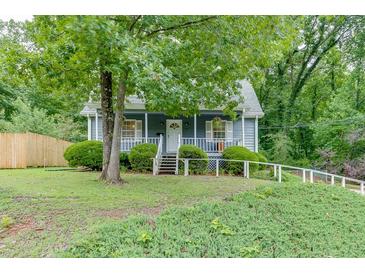Charming blue home with a white picket fence and lush green landscaping at 859 Sangria Ct, Lawrenceville, GA 30043