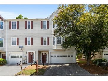Traditional townhome featuring red shutters, mature landscaping, and attached one-car garage at 2061 Pinnacle Pointe Dr, Norcross, GA 30071
