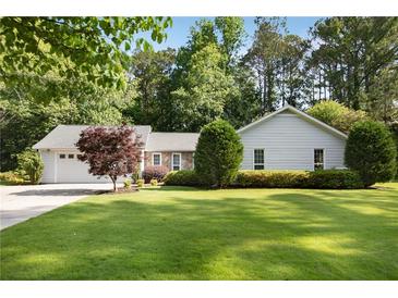 Charming single-story home featuring a well-maintained lawn, attached garage, and mature landscaping at 3519 Oak Knoll Dr, Marietta, GA 30068