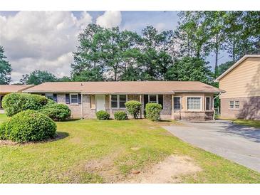 Charming single-story home with a well-maintained lawn, mature landscaping, and inviting curb appeal at 3420 Leisure Ln, Atlanta, GA 30349
