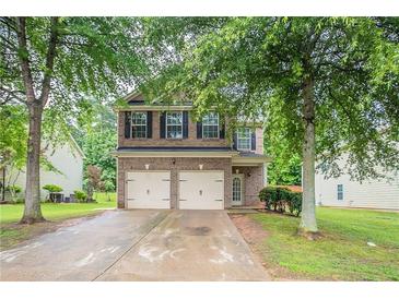 Charming two-story brick home with a two-car garage and a well-maintained front yard at 3469 Stoneleigh Walk, Lithonia, GA 30038