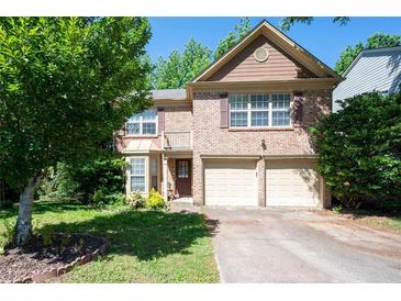 Traditional two-story brick home featuring an attached two-car garage and a well maintained lawn at 4003 Maple Ridge Nw Ln, Acworth, GA 30101