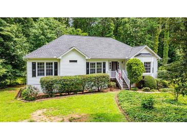 Charming ranch-style home with a well-manicured lawn, lush landscaping, and inviting front porch at 567 Leah Drive, Powder Springs, GA 30127