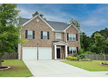 Charming two-story brick home with a two-car garage and well-maintained lawn at 735 Sweethaven Ln, Loganville, GA 30052