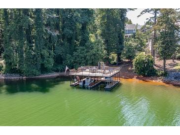 This waterfront property features a private dock, boat slip and relaxing seating area perfect for entertaining at 3441 Shoreland Dr, Buford, GA 30518