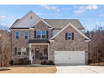 Charming two-story brick home featuring a welcoming front porch and attached two-car garage at 242 Crestbrook Ln, Dallas, GA 30157