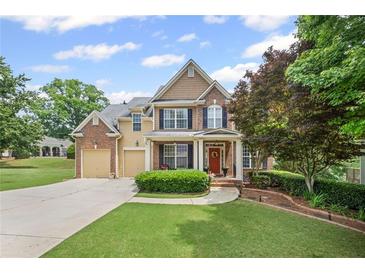 Charming two-story home boasts a manicured lawn, brick accents, and inviting front porch at 6597 River Island Drive Dr, Buford, GA 30518