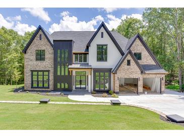 A beautiful two-story brick home featuring a three-car garage and a well-manicured lawn and garden at 4459 Grady Smith Rd, Loganville, GA 30052