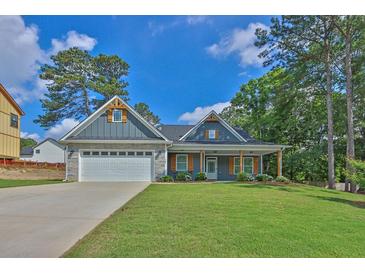 Charming single-story home featuring stone accents, a two-car garage, and a beautifully landscaped front yard at 145 Millennial Ct, Lawrenceville, GA 30045