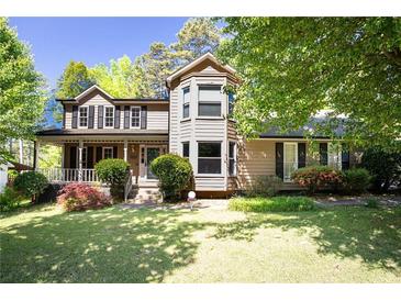 Charming two-story home featuring a welcoming porch and lush landscaping at 2889 Carrousel Ct, Stone Mountain, GA 30087