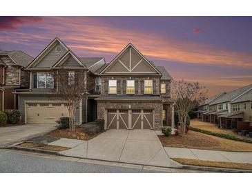 Beautiful two-story brick home featuring a two-car garage and a well-maintained front yard against a colorful sunset sky at 5621 Cobblestone Creek Ave # 14, Mableton, GA 30126
