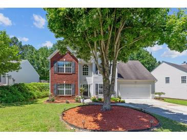 Charming two-story home with brick and siding exterior, mature tree, and well-maintained lawn at 3234 Baymount Way, Lawrenceville, GA 30043