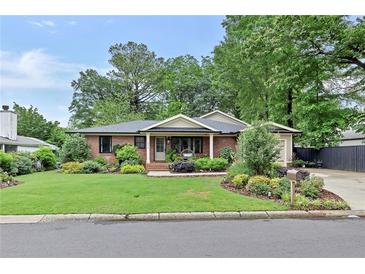 Charming brick home with a well-manicured lawn and lush landscaping adding curb appeal at 236 Ridge Nw Ave, Marietta, GA 30064
