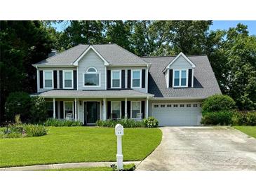 Charming two-story home with a well-manicured lawn and a welcoming front porch at 25 Jessamine Trail Trl, Lawrenceville, GA 30046