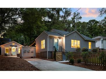 Charming home with a fenced yard, featuring a blue front door and tasteful landscaping at 1583 Braeburn Se Dr, Atlanta, GA 30316