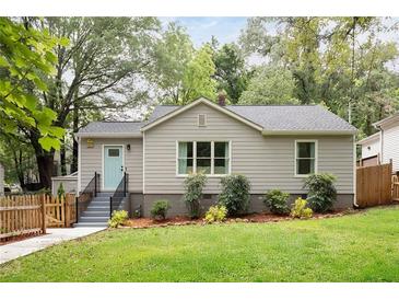 Charming home with a well-maintained lawn, complemented by freshly mulched flower beds and a cheerful light blue front door at 1583 Braeburn Se Dr, Atlanta, GA 30316