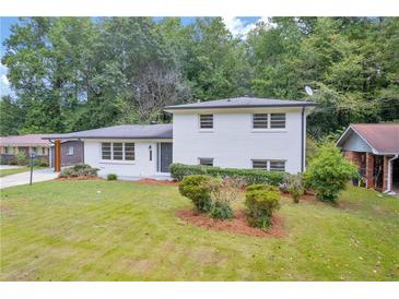 Charming white brick home with manicured lawn and mature trees providing a picturesque setting at 2678 Rainbow Forest Dr, Decatur, GA 30034
