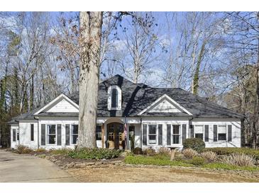 Charming single-Gathering home with a manicured front yard and classic architectural details and mature trees at 6170 Wellington Ct, Cumming, GA 30040