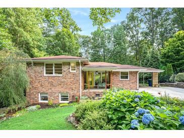 Charming brick home with a well-manicured front yard featuring lush greenery and colorful hydrangea bushes at 1706 Remington Rd, Atlanta, GA 30341