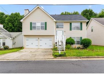 Charming two-story home with a two-car garage, green shutters, and a small, landscaped front yard at 3599 Salem Glen Rd, Lithonia, GA 30038