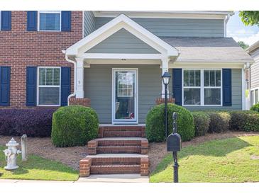 Charming home entrance features brick steps, manicured shrubs and a stylish glass front door at 577 Cypher Drive, Suwanee, GA 30024