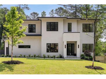 Striking modern home featuring a manicured lawn, elegant landscaping, and a sleek contemporary design at 3293 Lenox Ne Pl, Atlanta, GA 30324