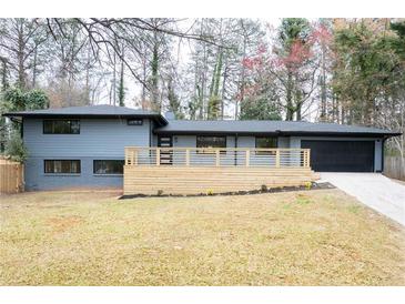 Charming home with modern gray brick, new deck, and a black garage door at 1120 Taliwa Ne Trl, Marietta, GA 30068