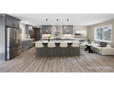 Bright, open kitchen with stainless steel appliances, a large island with seating, and gray cabinets and island at 1120 Taliwa Ne Trl, Marietta, GA 30068