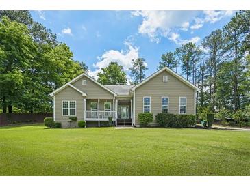 Charming one-story home with a covered front porch, lush lawn, and mature trees at 380 Russell Rd, Lawrenceville, GA 30043