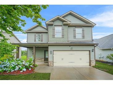 Charming two-story home with a two-car garage, inviting covered porch, and well-manicured lawn at 2166 Villa Spring Ct, Dacula, GA 30019