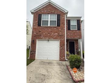 Charming brick home featuring a single car garage and well maintained landscaping at 2080 Belmont Cir, Conyers, GA 30012
