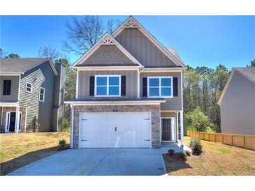 Charming two-story home featuring a stone-accented garage and a well-manicured front lawn, perfect for curb appeal at 335 Melody Ne Ln, Cartersville, GA 30121