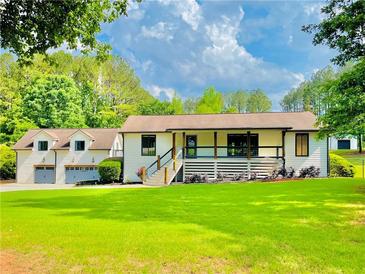 Inviting exterior view of a two-story home with a spacious front yard and a large garage at 345 Etheridge Rd, Auburn, GA 30011