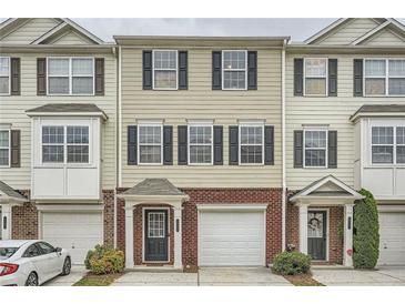 Attractive townhome featuring tan siding, brick accents, black shutters, attached garages and a welcoming front entrance at 6895 Slate Stone Se Way # 3, Mableton, GA 30126