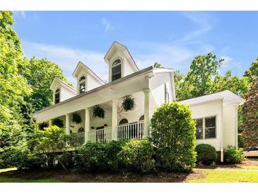 Charming home featuring a columned front porch with hanging plants and dormer windows at 7212 Avalon Dr, Douglasville, GA 30135