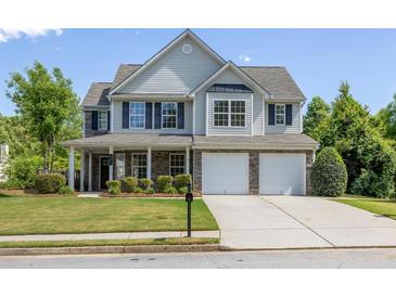 Charming two-story home with a well-manicured lawn and a two-car garage at 895 Roxfield Ct, Buford, GA 30518
