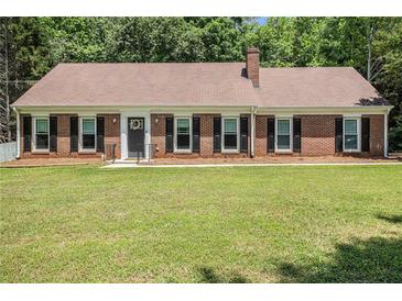 Charming ranch-style home with brick facade, black shutters, and a well-maintained front yard at 1828 Brandy Woods Se Dr, Conyers, GA 30013