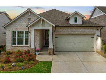 Charming single-Gathering home featuring brick facade, manicured landscaping, and attached two-car garage at 209 Floral Valley Dr, Woodstock, GA 30188
